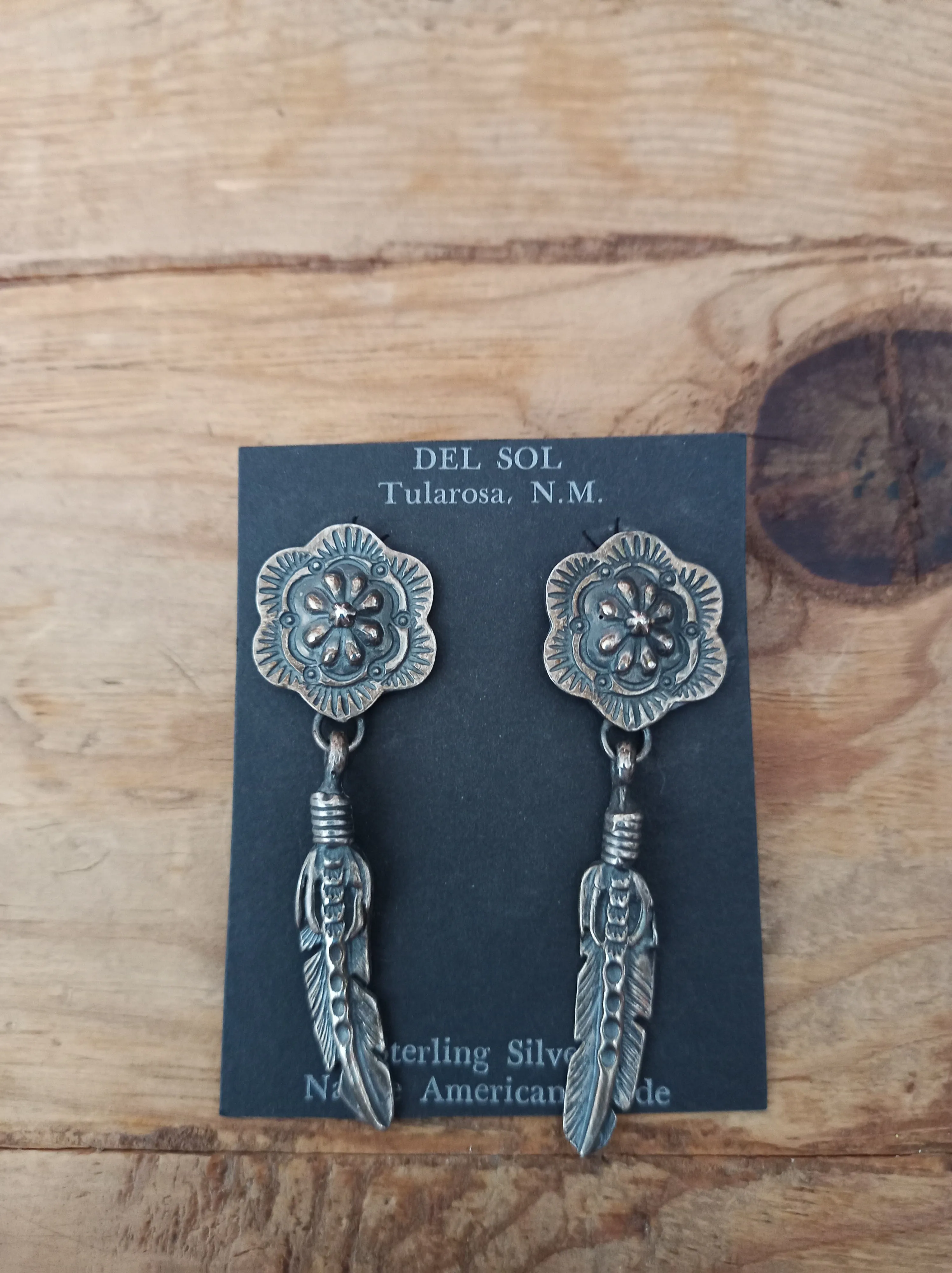 Concho and feather. Native American handcrafted sterling silver earrings, Navajo
